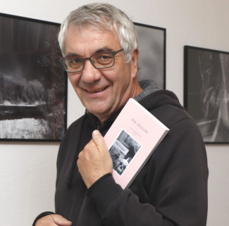 Journalist und Autor Klaus Kuhn hält sein Buch "Die Zeugin" in der Hand.